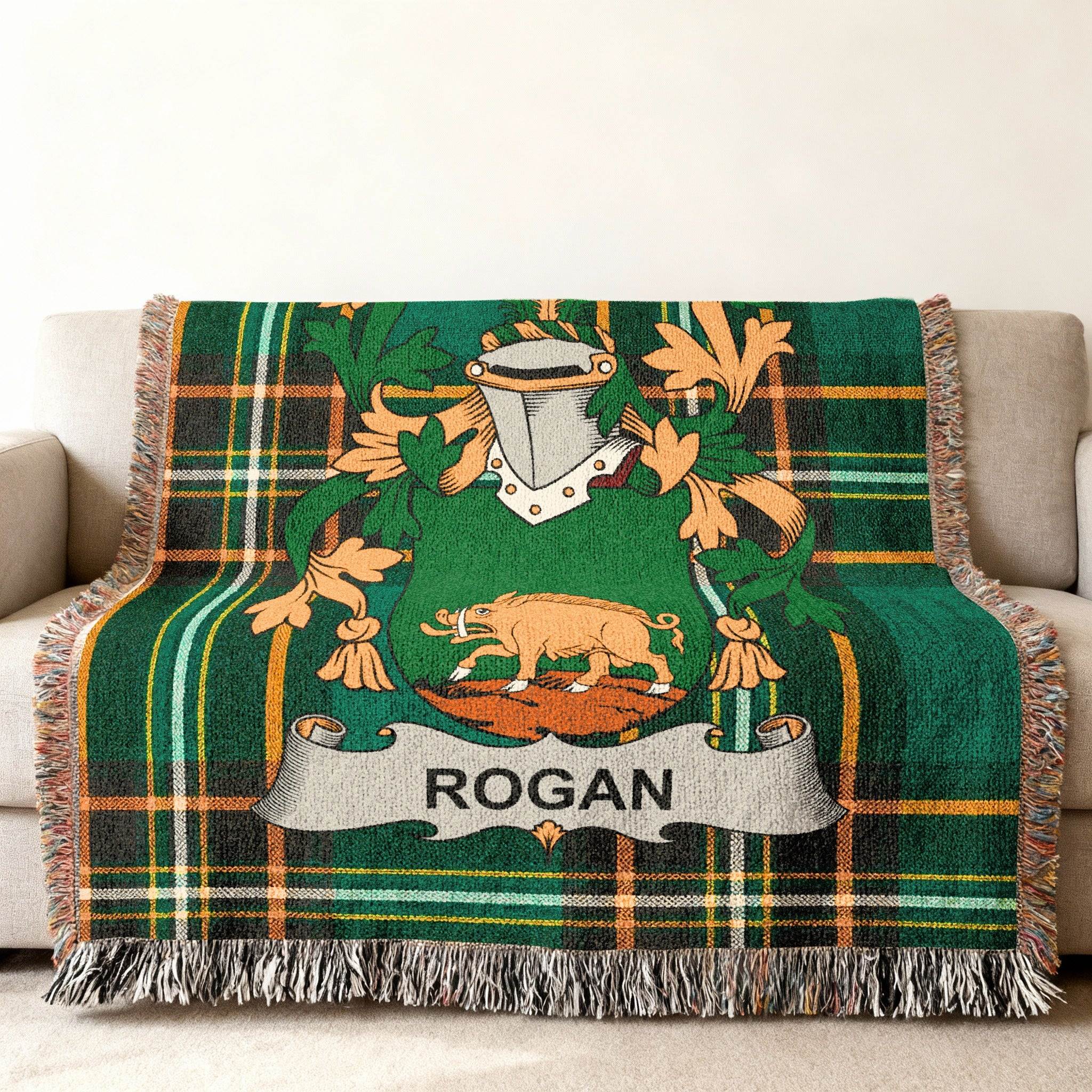 Green tartan throw blanket with Rogan family crest featuring a boar.