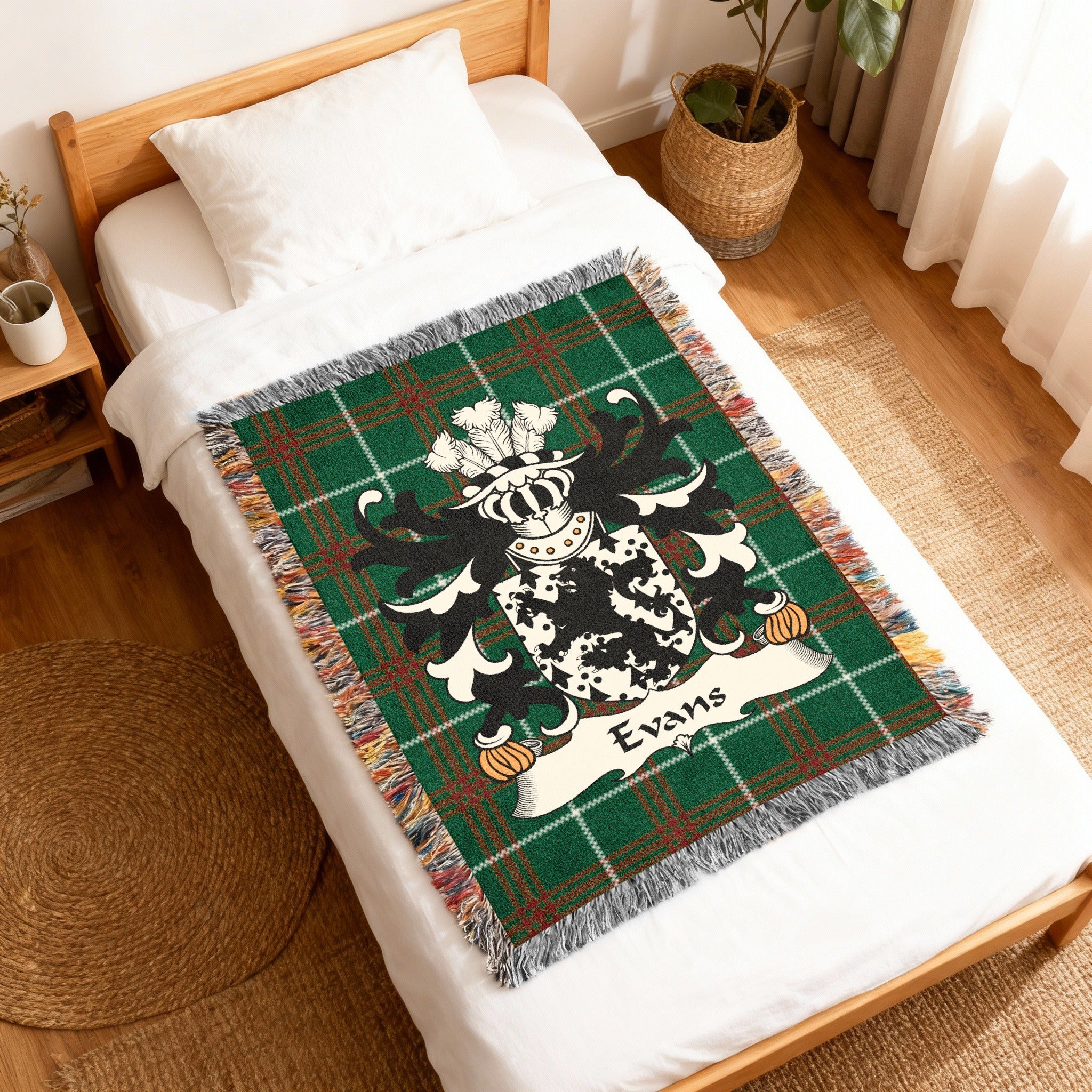Green tartan woven blanket with a black and white coat of arms and "Evans" text.