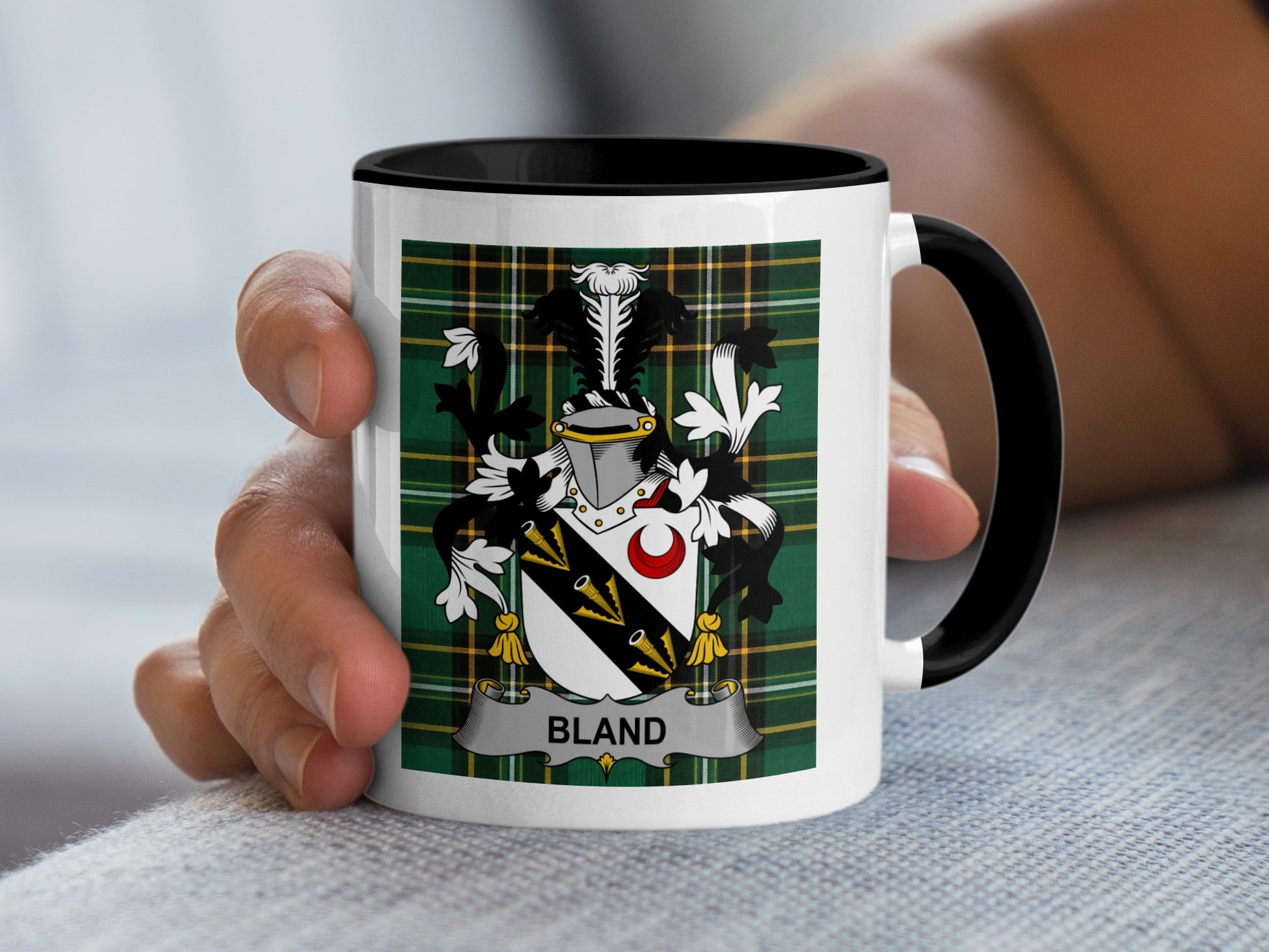 White mug with black handle featuring a green tartan plaid and a coat of arms with the name "BLAND".