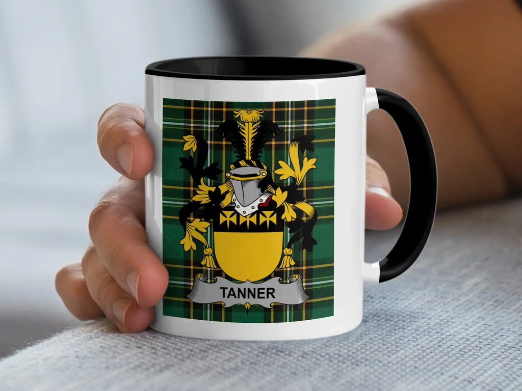 Mug with black handle featuring the Tanner family crest on a tartan background.