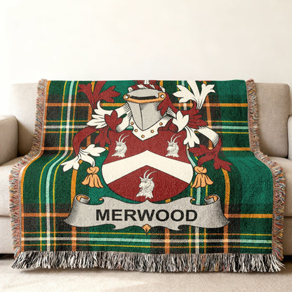 Woven tartan blanket with Merwood family crest on a couch.