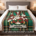 Green tartan blanket with Owens family crest on a bed.