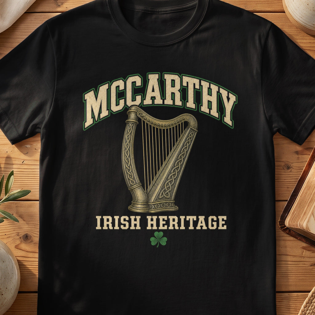 McCarthy Irish harp T-shirt in Black, with cream surname lettering, a gold-toned harp, green shamrock and “Irish Heritage” text.