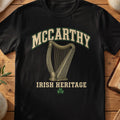 McCarthy Irish harp T-shirt in Black, with cream surname lettering, a gold-toned harp, green shamrock and “Irish Heritage” text.