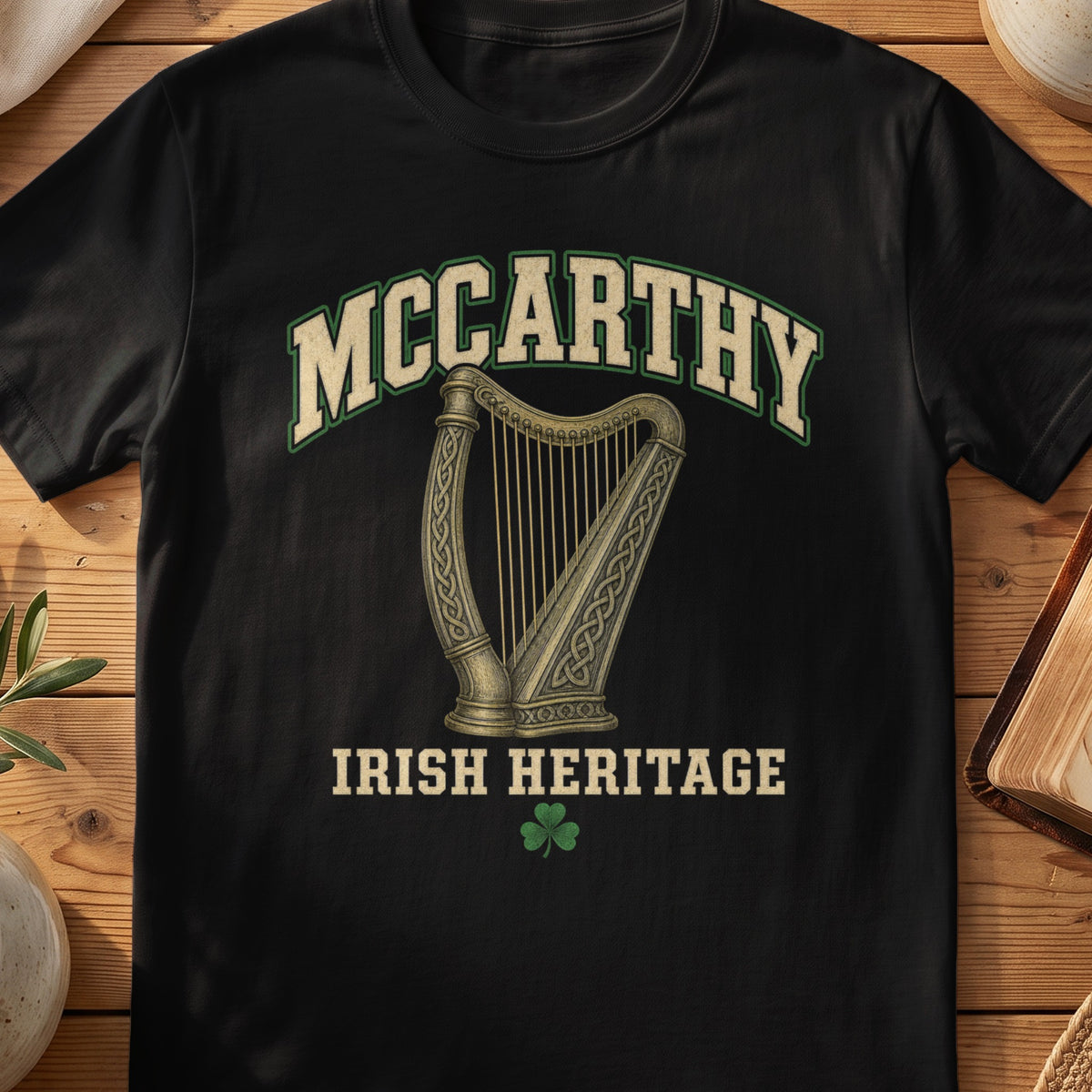 McCarthy Irish harp T-shirt in Black, with cream surname lettering, a gold-toned harp, green shamrock and “Irish Heritage” text.
