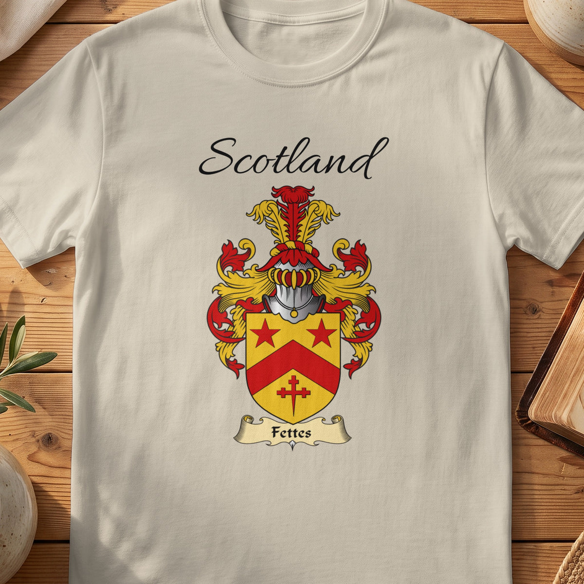 Sand Fettes Scottish family shield T-shirt featuring a red chevron and stars on a gold shield