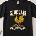 Sinclair graphic T-shirt in Black, front flat lay showing varsity lettering and gold rooster with red comb and wattle.