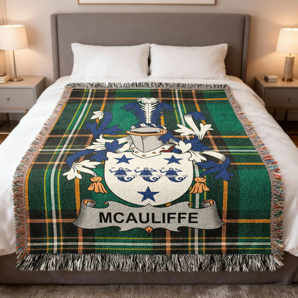 McAULIFFE family crest on a green and black tartan throw blanket on a bed.