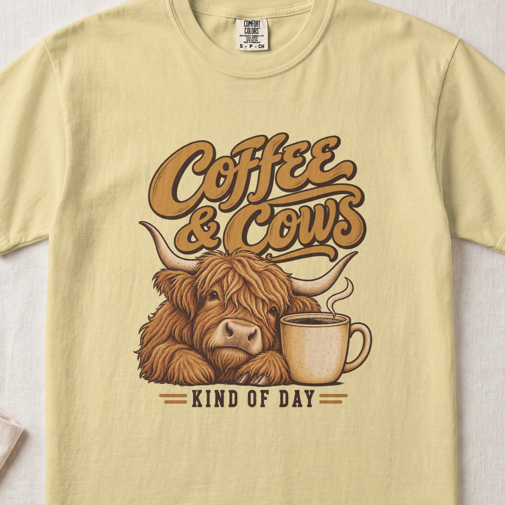 Coffee & Cows Kind of Day Highland cow design on a Butter Comfort Colors 1717 T-shirt, flat lay