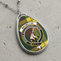 MacMillan clan crest pendant with tartan background and sword.