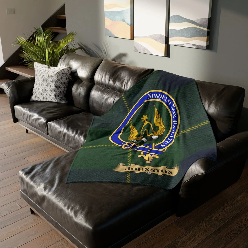 Johnston clan crest tartan throw blanket on leather couch — 50x60 polyester, Nunquam Non Paratus heraldic design