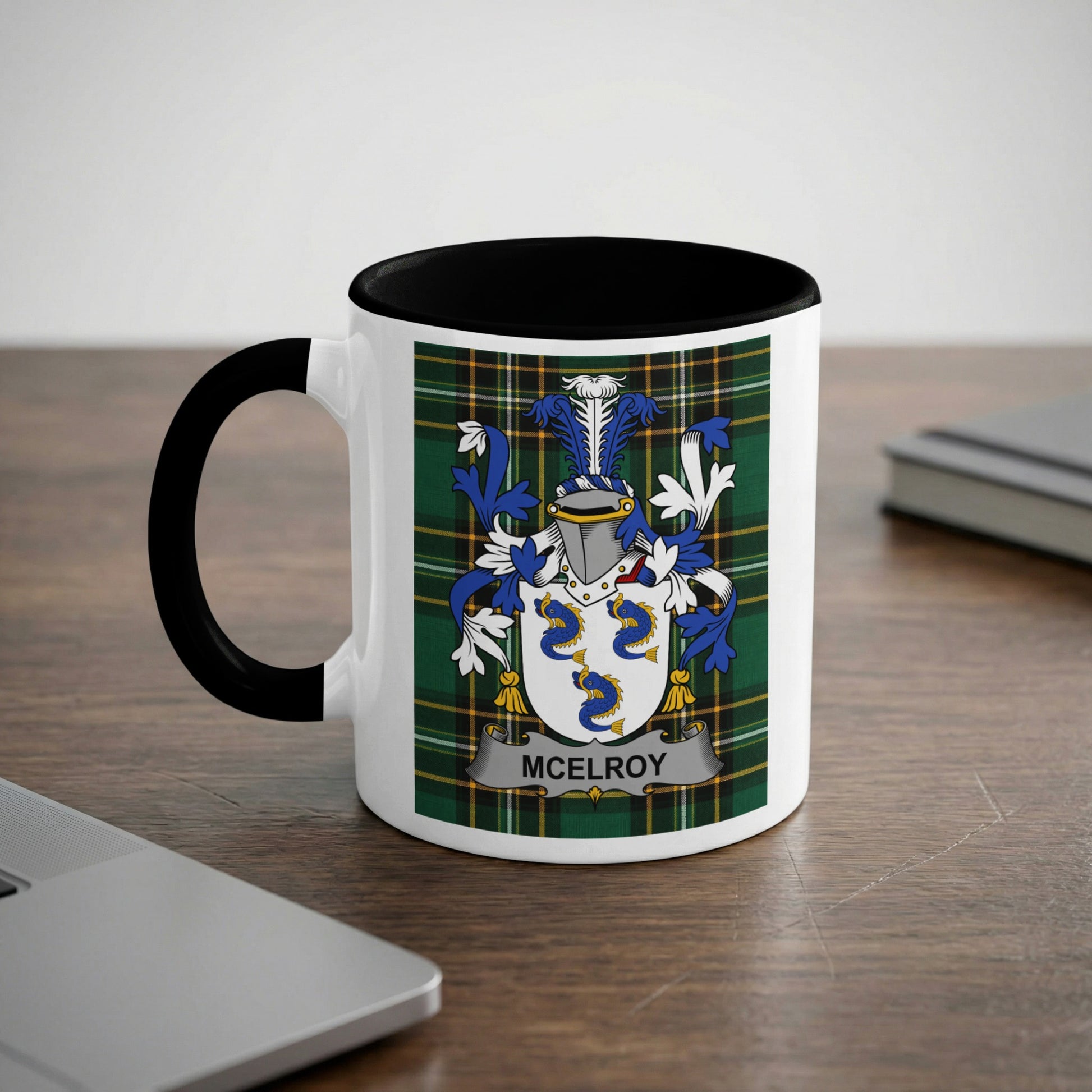 White mug with black handle featuring a green, blue, and yellow McElroy family crest.