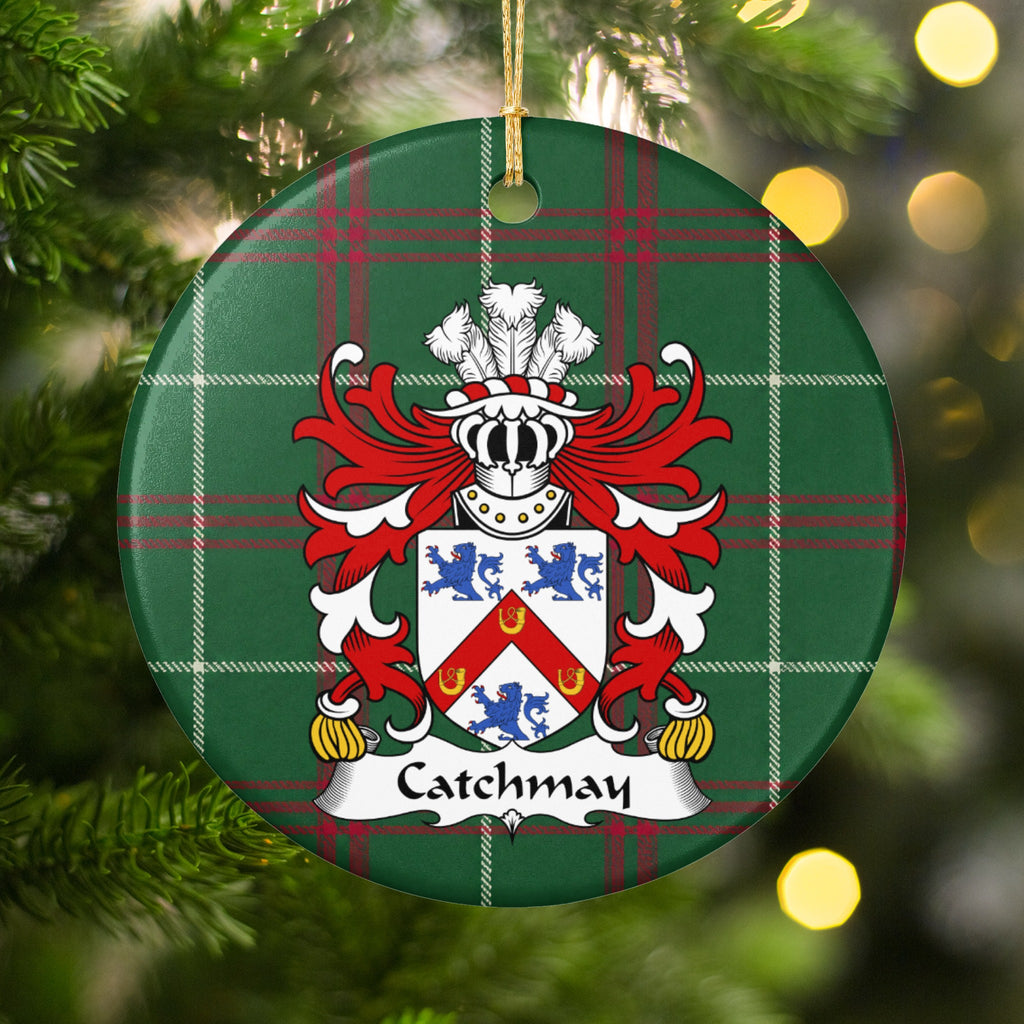Catchmay ornament hanging among Christmas tree branches and warm lights; a red chevron bearing three gold horseshoes between three blue lions on a white shield on Welsh national tartan.