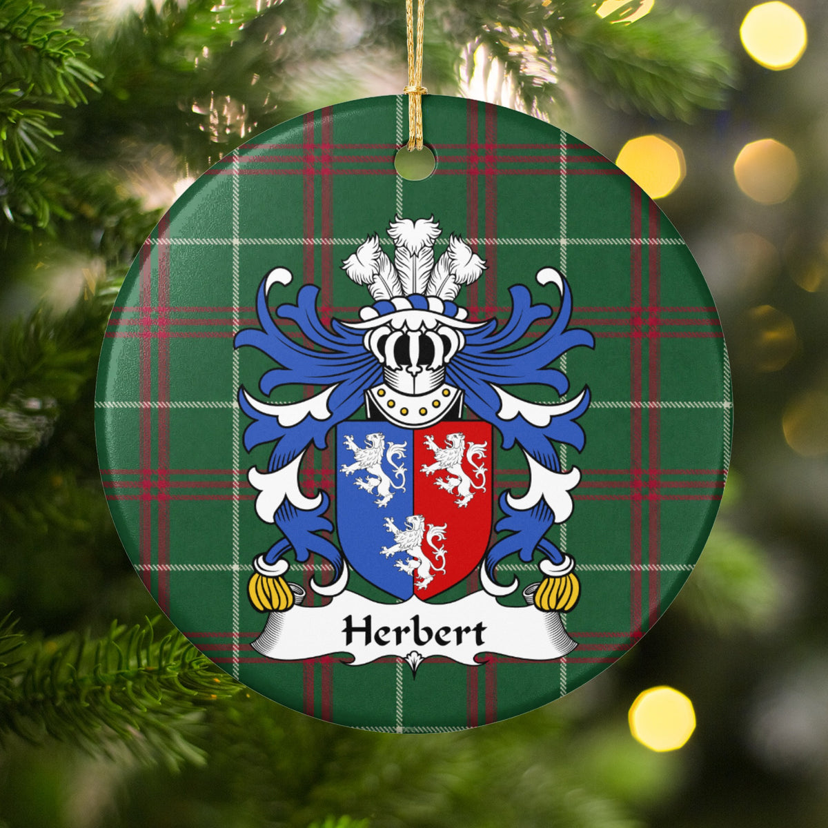 Herbert ornament hanging in a Christmas tree with warm lights; three white lions on a vertically divided blue-and-red shield on Welsh national tartan.