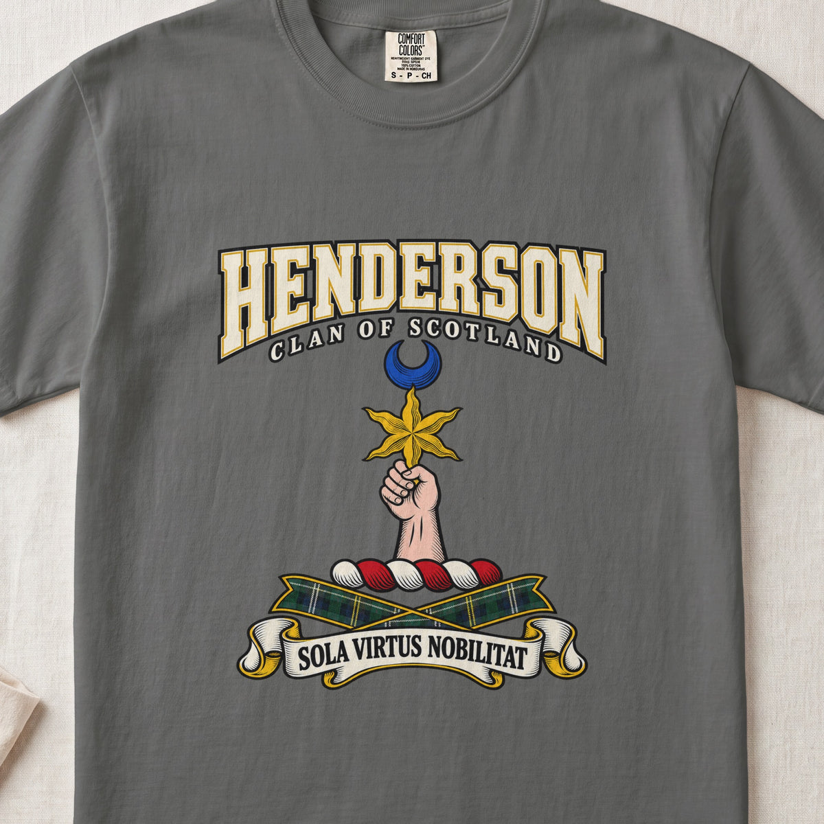 Pepper Henderson Scottish clan T-shirt, front flat lay with varsity lettering, star-and-crescent crest and tartan ribbon.