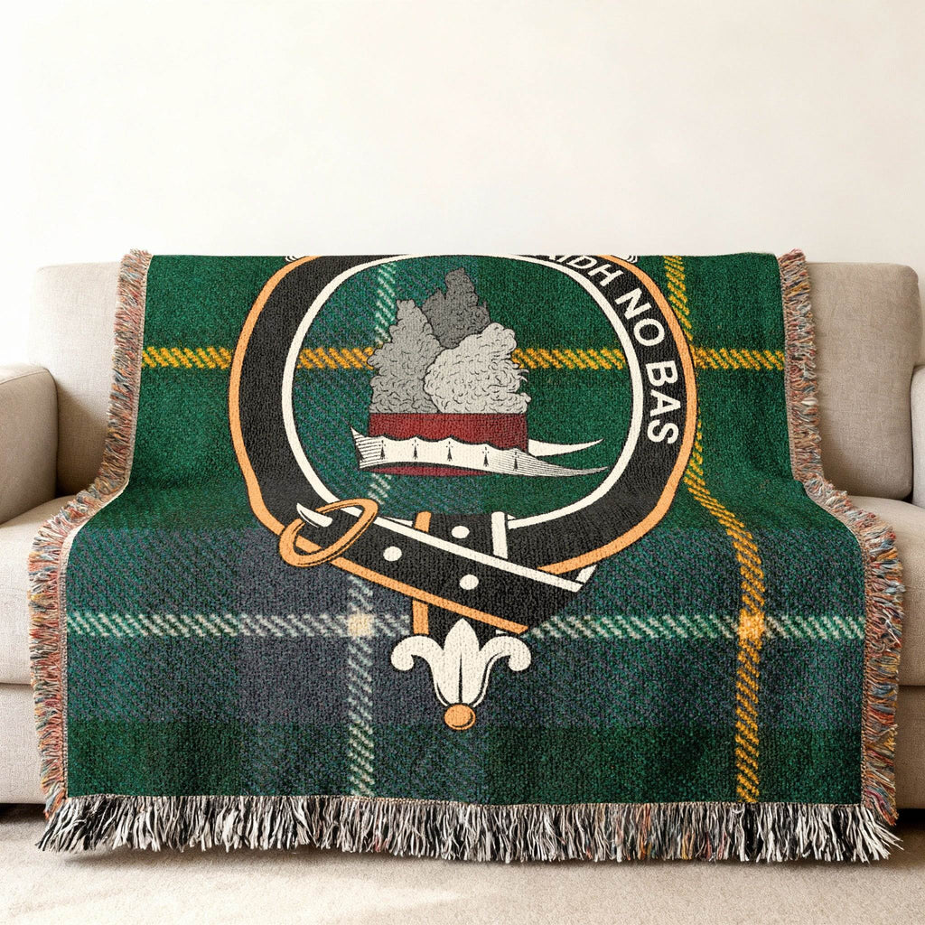 MacNeil clan crest tartan woven throw blanket draped over sofa — full pattern in clan colours