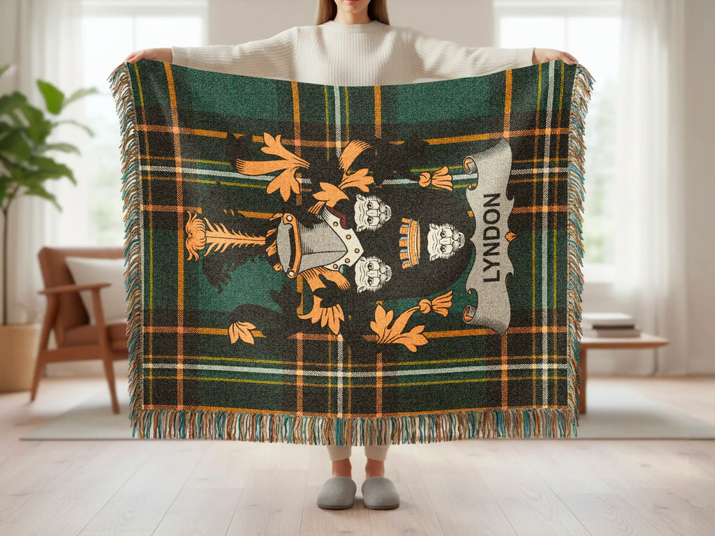 Tartan blanket with crest and "Lyndon" text, held by a person.