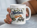 White mug with "Born to Blether, Forced to Work" text and Scottish thistle designs.