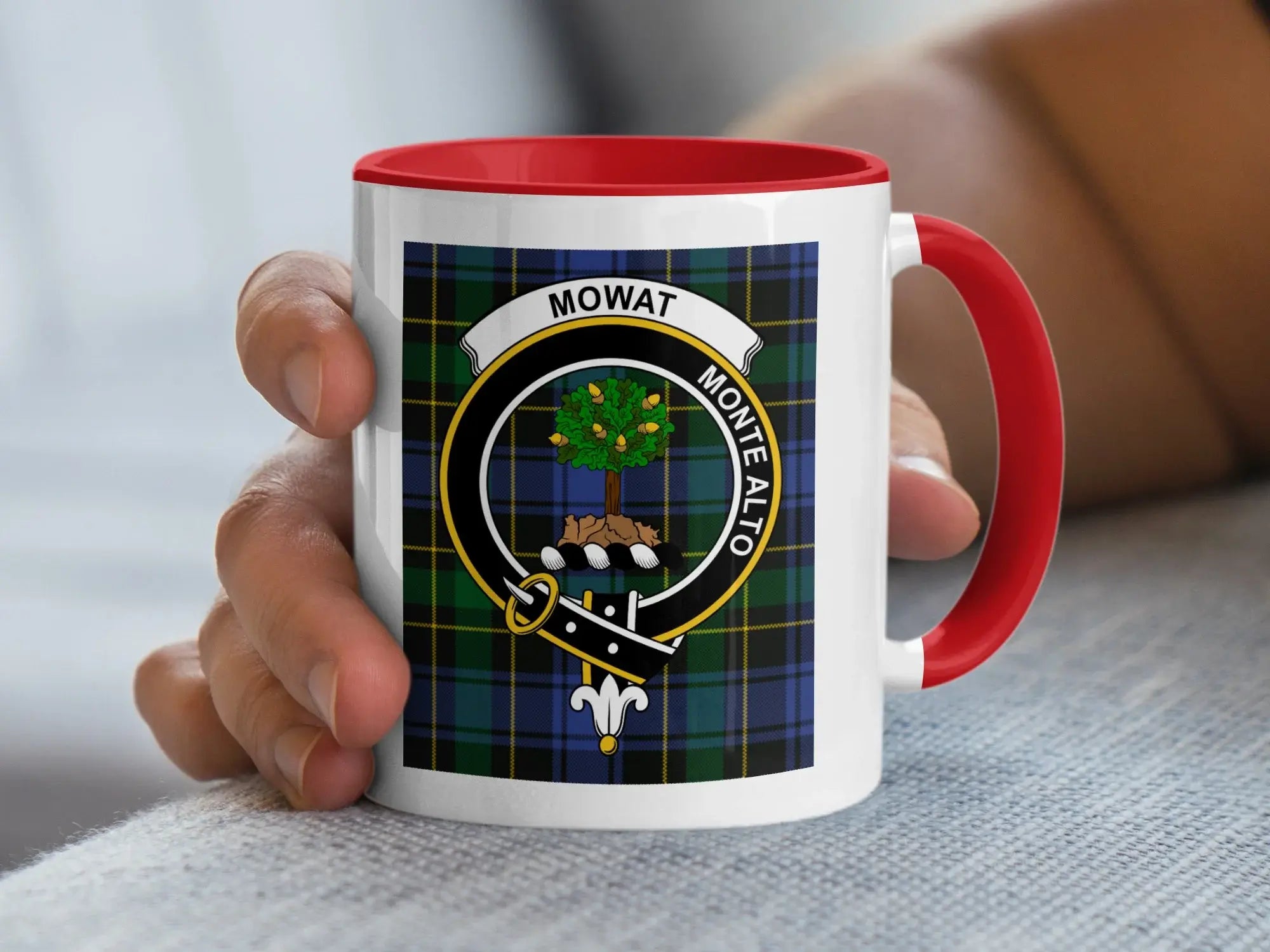 Mug with tartan pattern and "MOWAT MONTE ALTO" crest, held by hand.