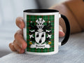 White mug with black handle featuring the Bennet family crest on a green tartan background.