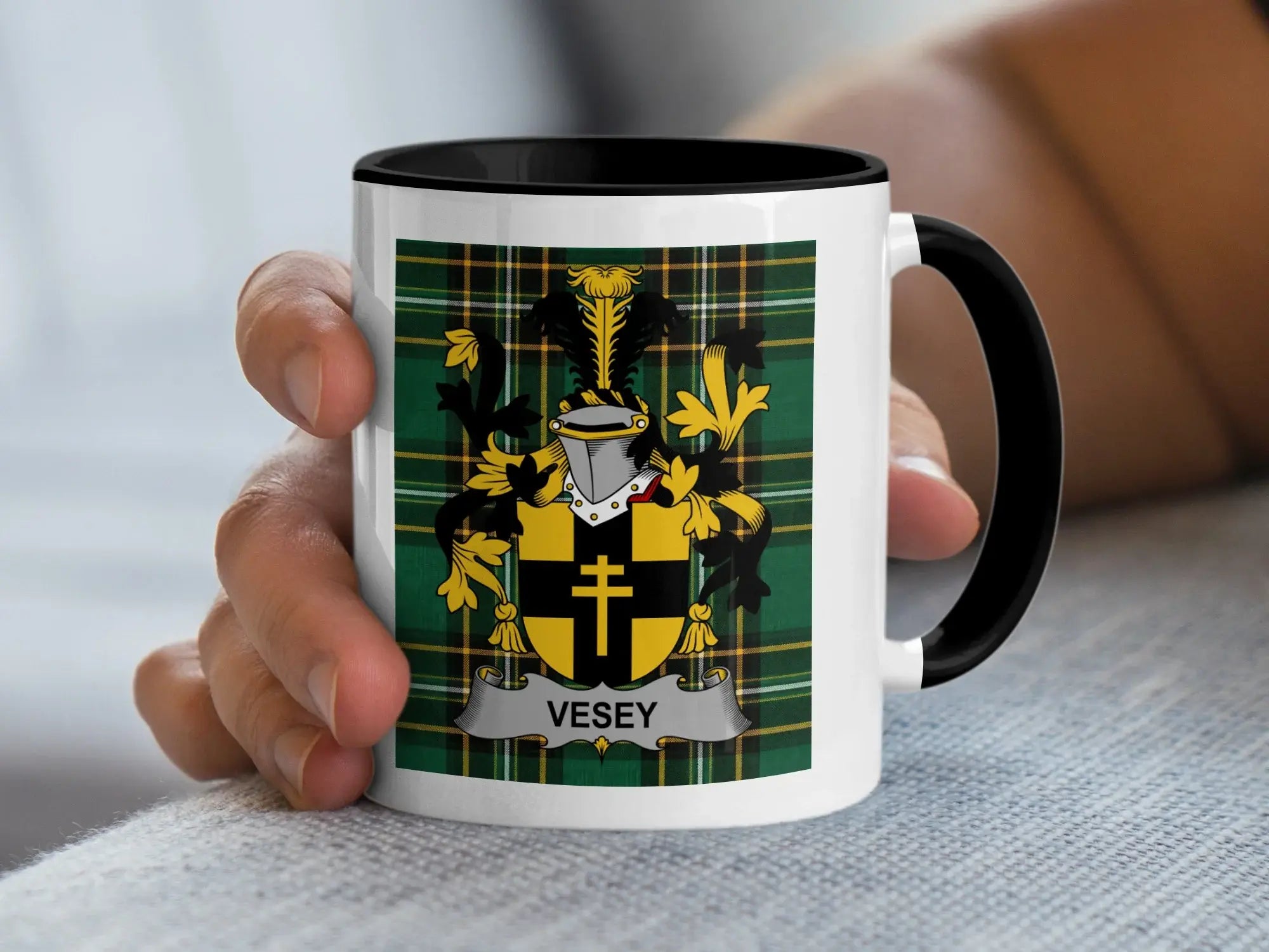 White mug with black rim, featuring a gold and black coat of arms with the name VESEY.