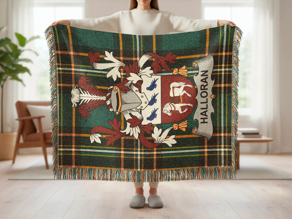 Tartan blanket with Halloran crest and fringe detail, held by person.