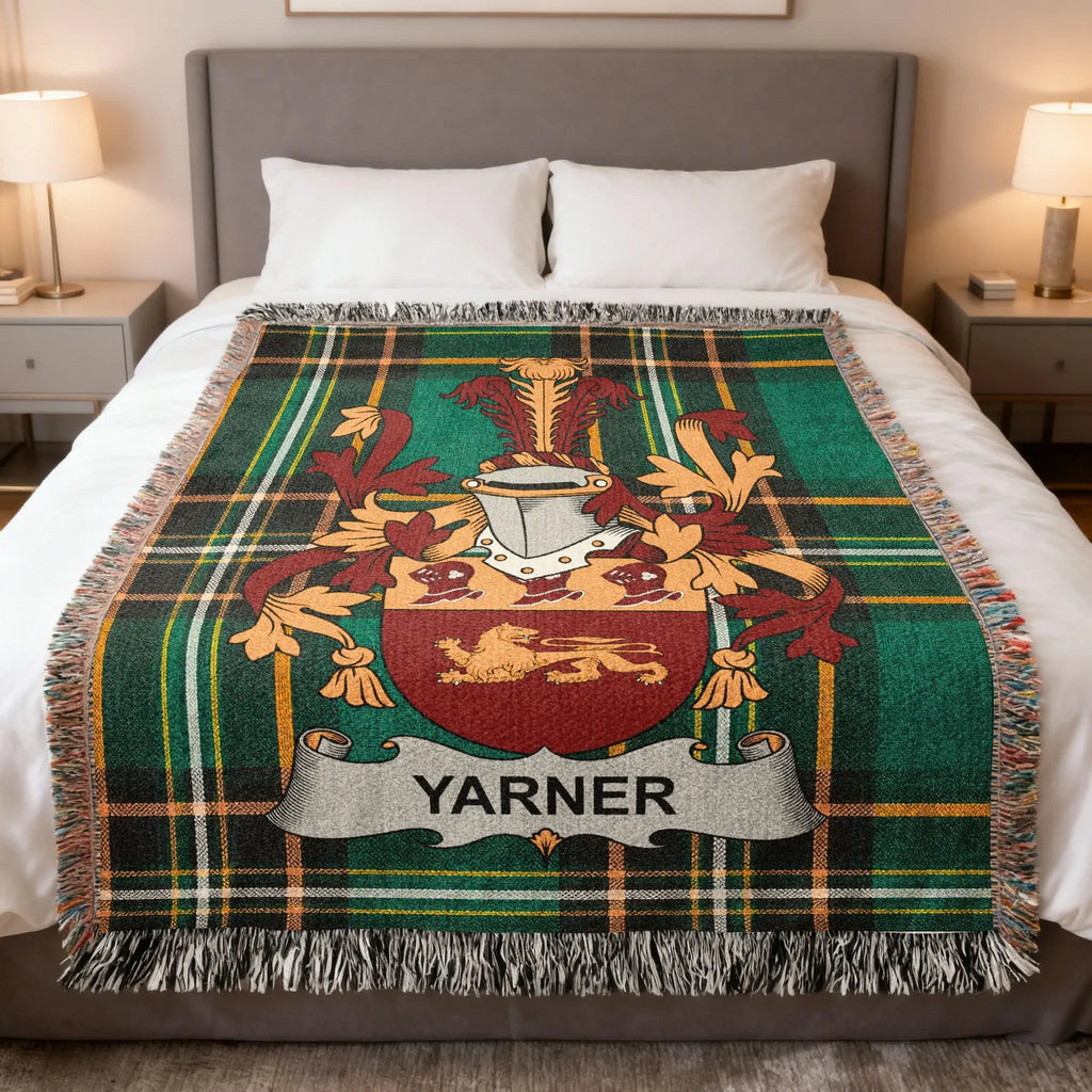 Yarner tartan blanket with coat of arms displayed on a bed.