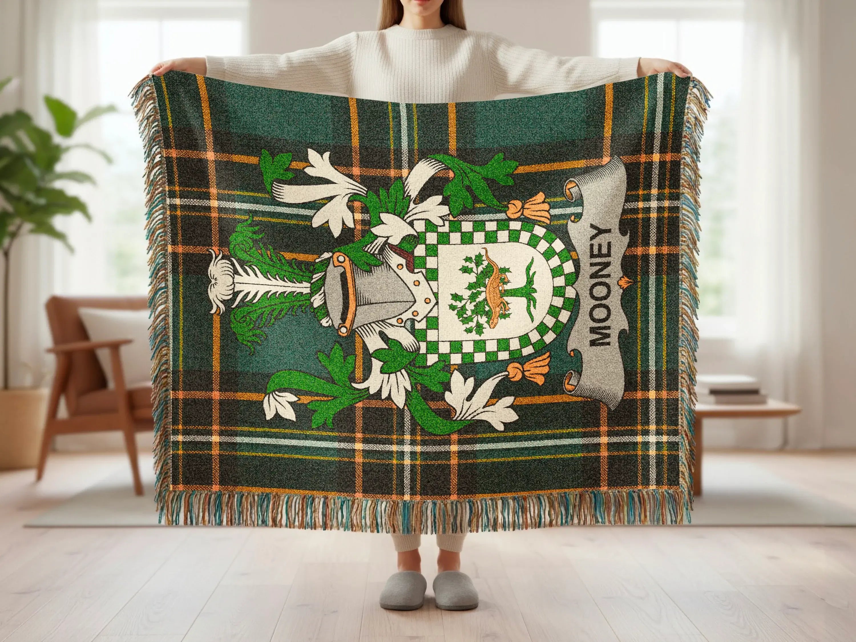 Tartan blanket with Mooney crest and fringe, held by a person.