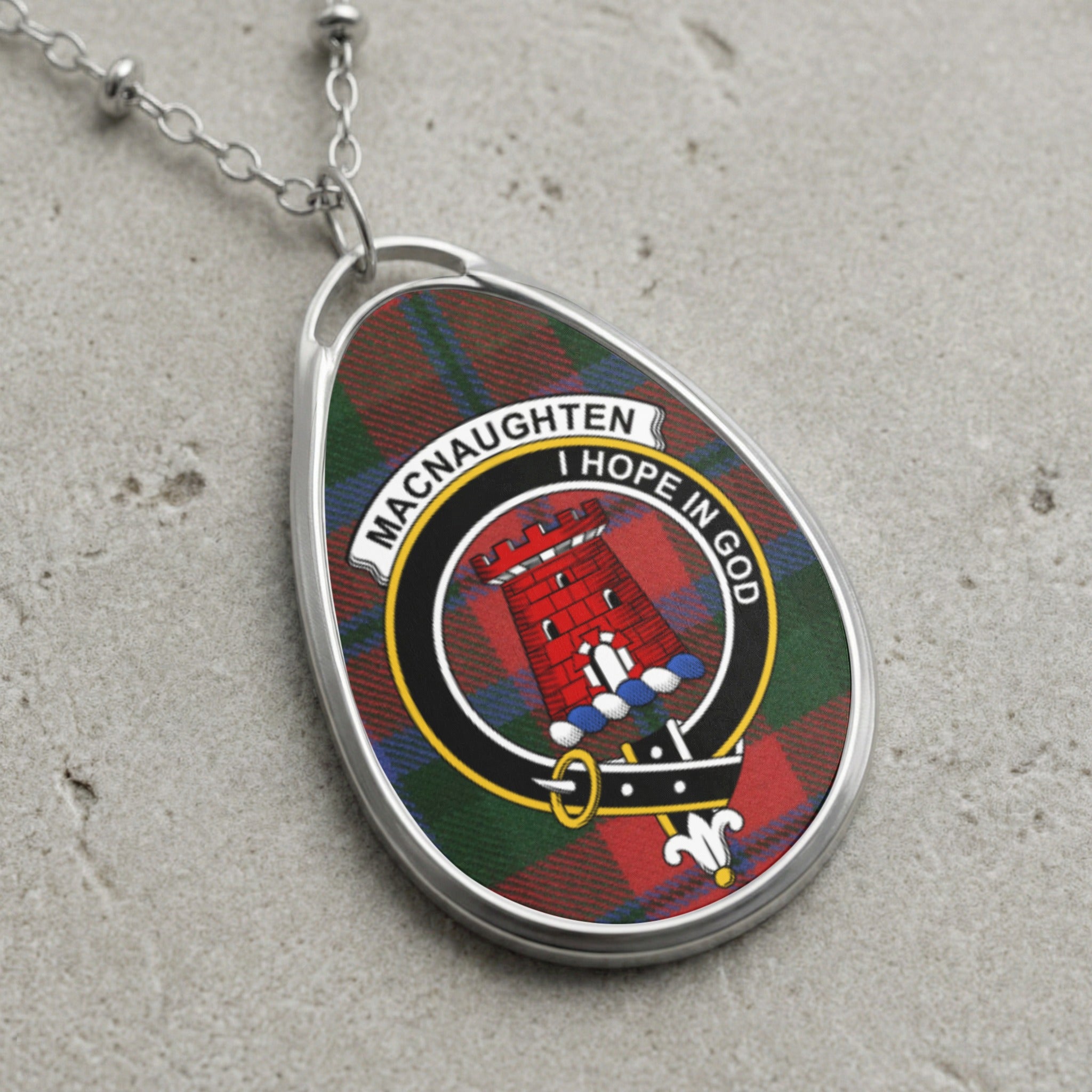 Macnaughten clan crest pendant on tartan background with Latin motto.