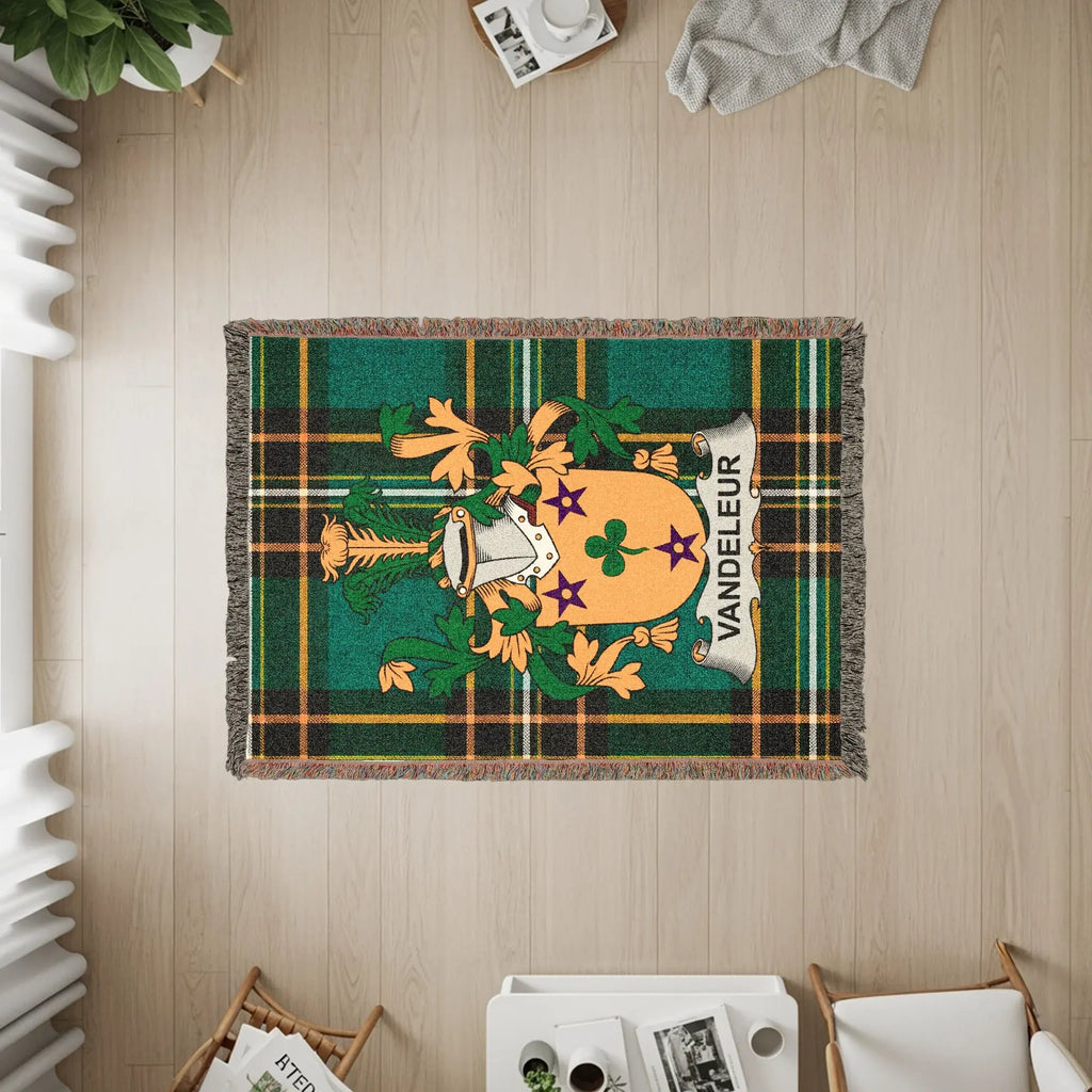 Vandeleur clan crest on a green tartan woven blanket with fringe.