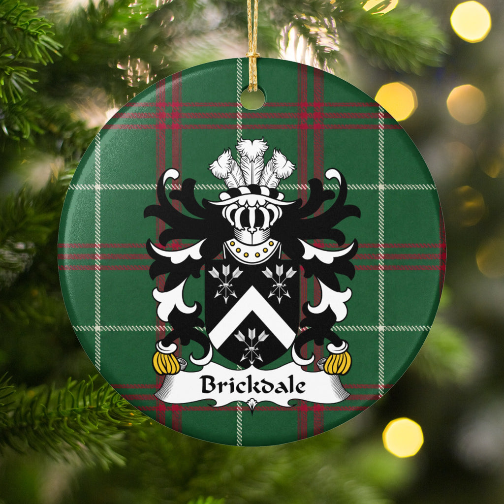 Brickdale ornament hanging in a Christmas tree with warm lights; a white chevron between three white arrow bundles on black on Welsh national tartan.