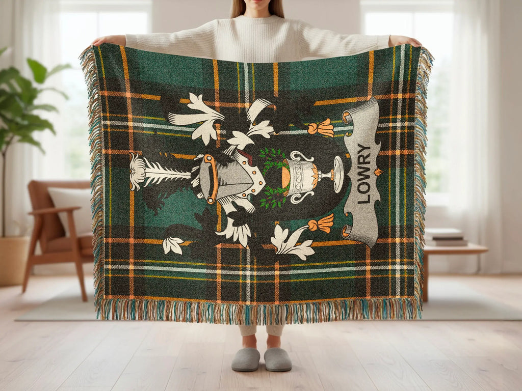 Lowry tartan blanket with a crest, held up by a person.