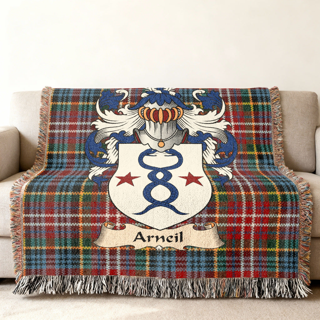 Arneil Scottish family shield woven blanket with Caledonia tartan background on a sofa