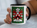 White mug with black handle, featuring the Griffith family crest on a green tartan pattern.