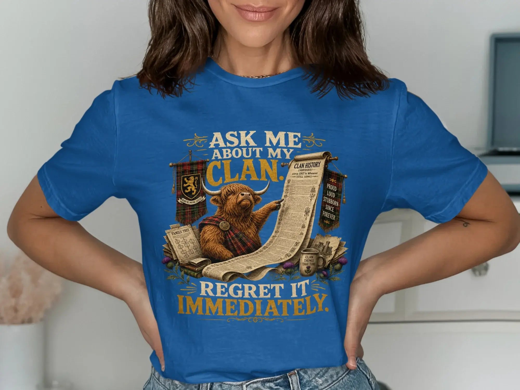 Blue t-shirt with Scottish Highland cow and text about clan history.