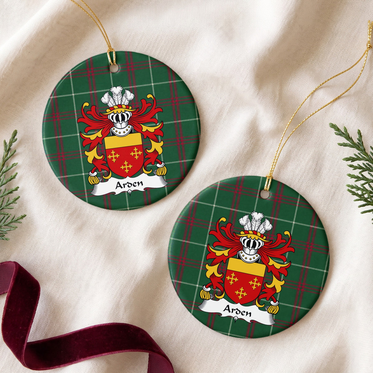Two Arden ornaments on cream fabric with evergreen and burgundy ribbon; three small gold crosses on red beneath a plain gold top band on Welsh national tartan.