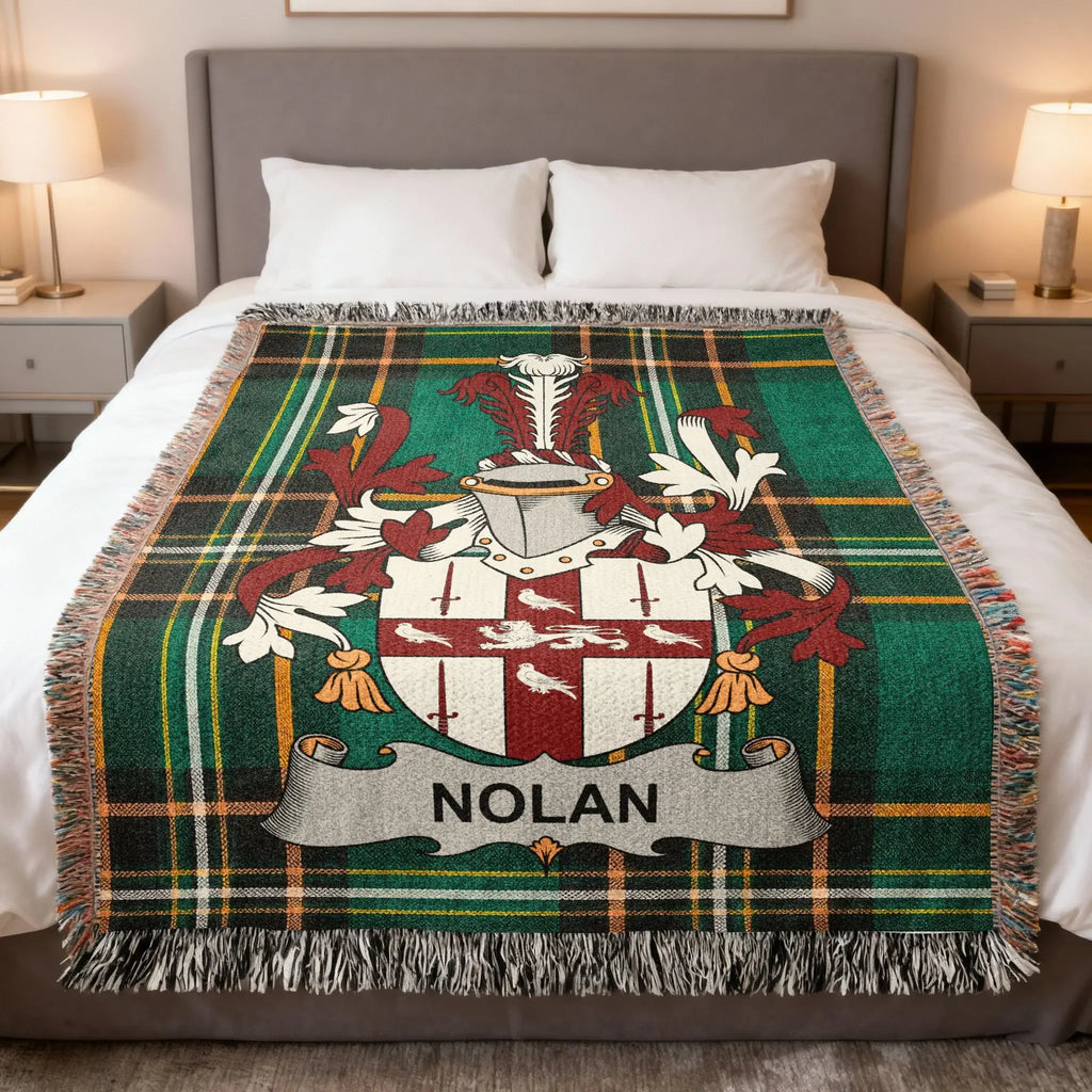 Green plaid blanket with Nolan family crest and fringe, draped on a bed.