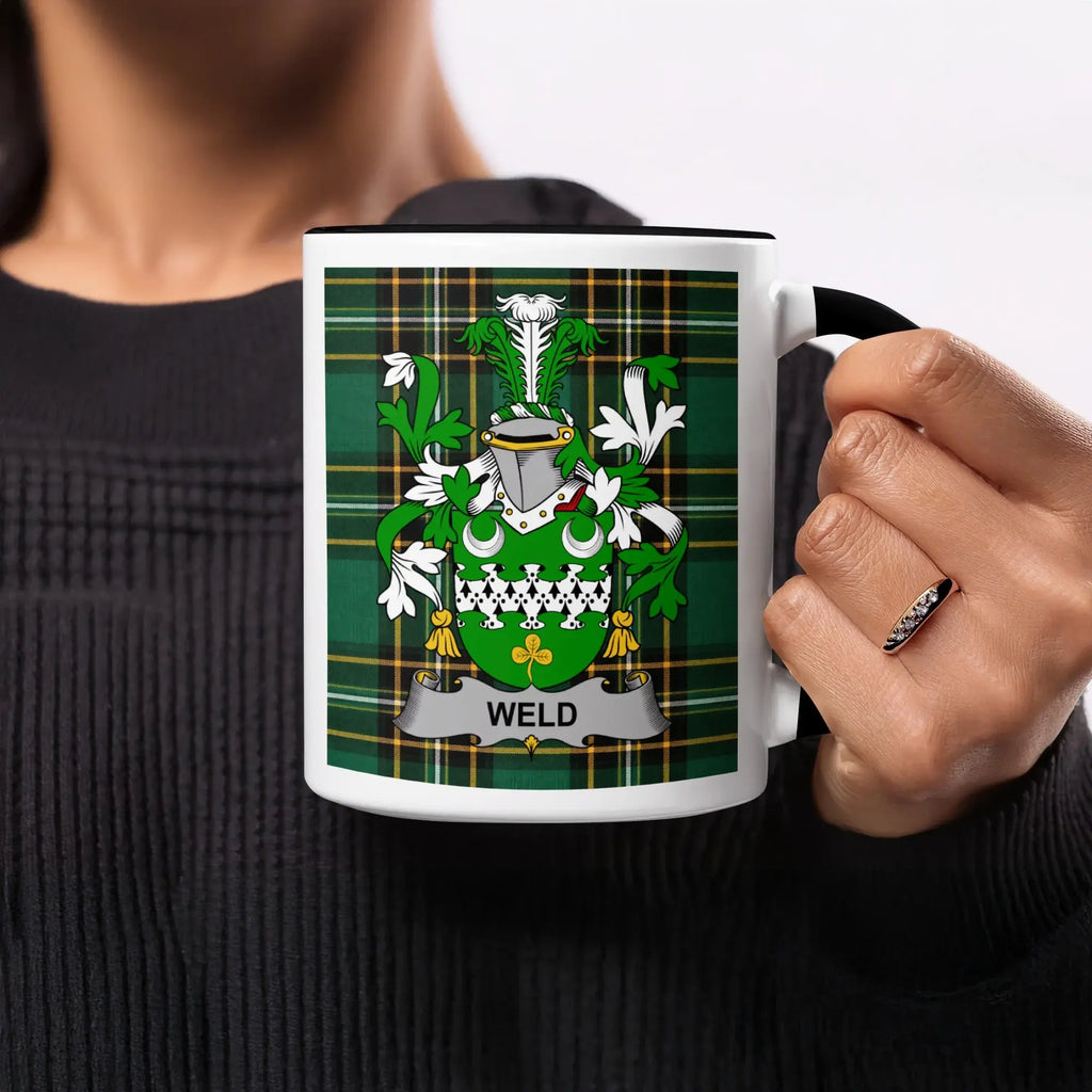 Coat of arms with "WELD" banner on a mug with plaid background.