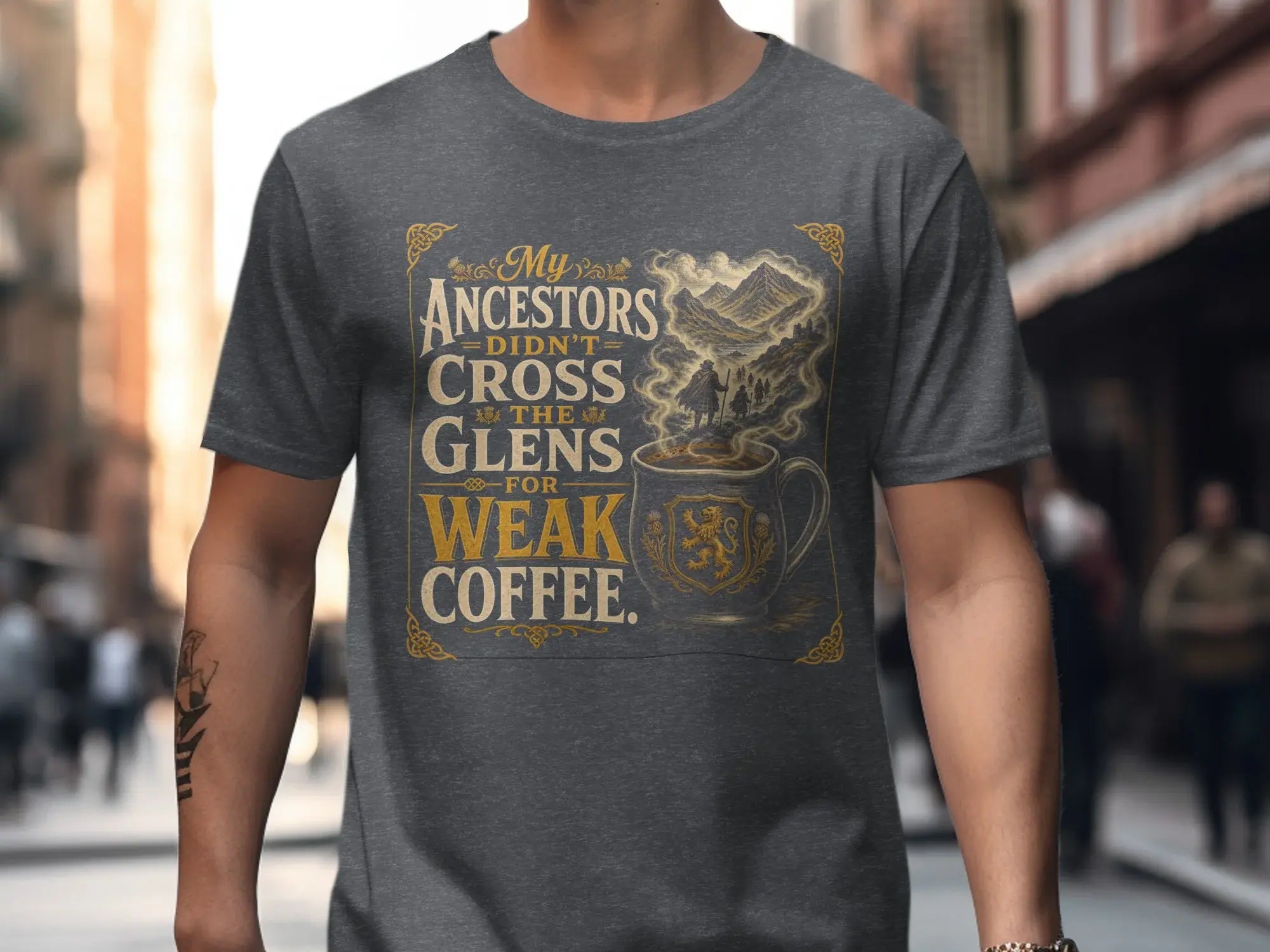 Grey t-shirt featuring "My Ancestors Didn't Cross the Glens for Weak Coffee" text and a Scottish lion emblem.
