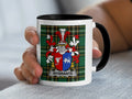 White mug with black rim featuring the Wybrants coat of arms on a plaid background.