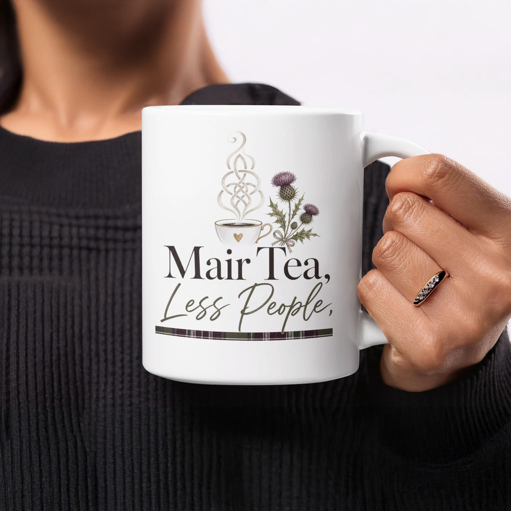 Mug with "Mair Tea, Less People" text, thistle, and Celtic knot.