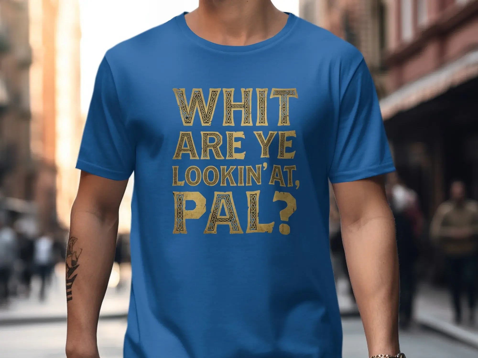 Blue t-shirt with gold text that reads "WHIT ARE YE LOOKIN' AT, PAL?"