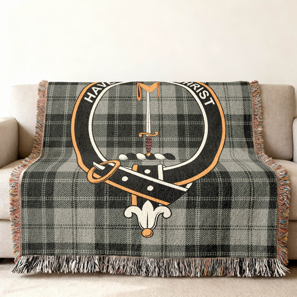 Glendinning clan crest woven blanket — sword and crest emblem visible in tartan weave pattern