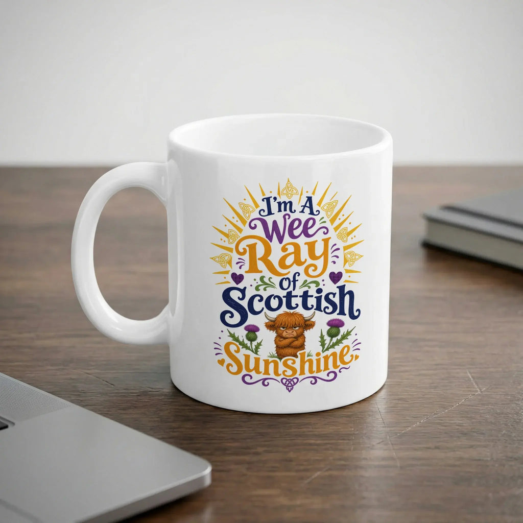 White mug with "I'm a Wee Ray of Scottish Sunshine" text and Highland cow graphic.