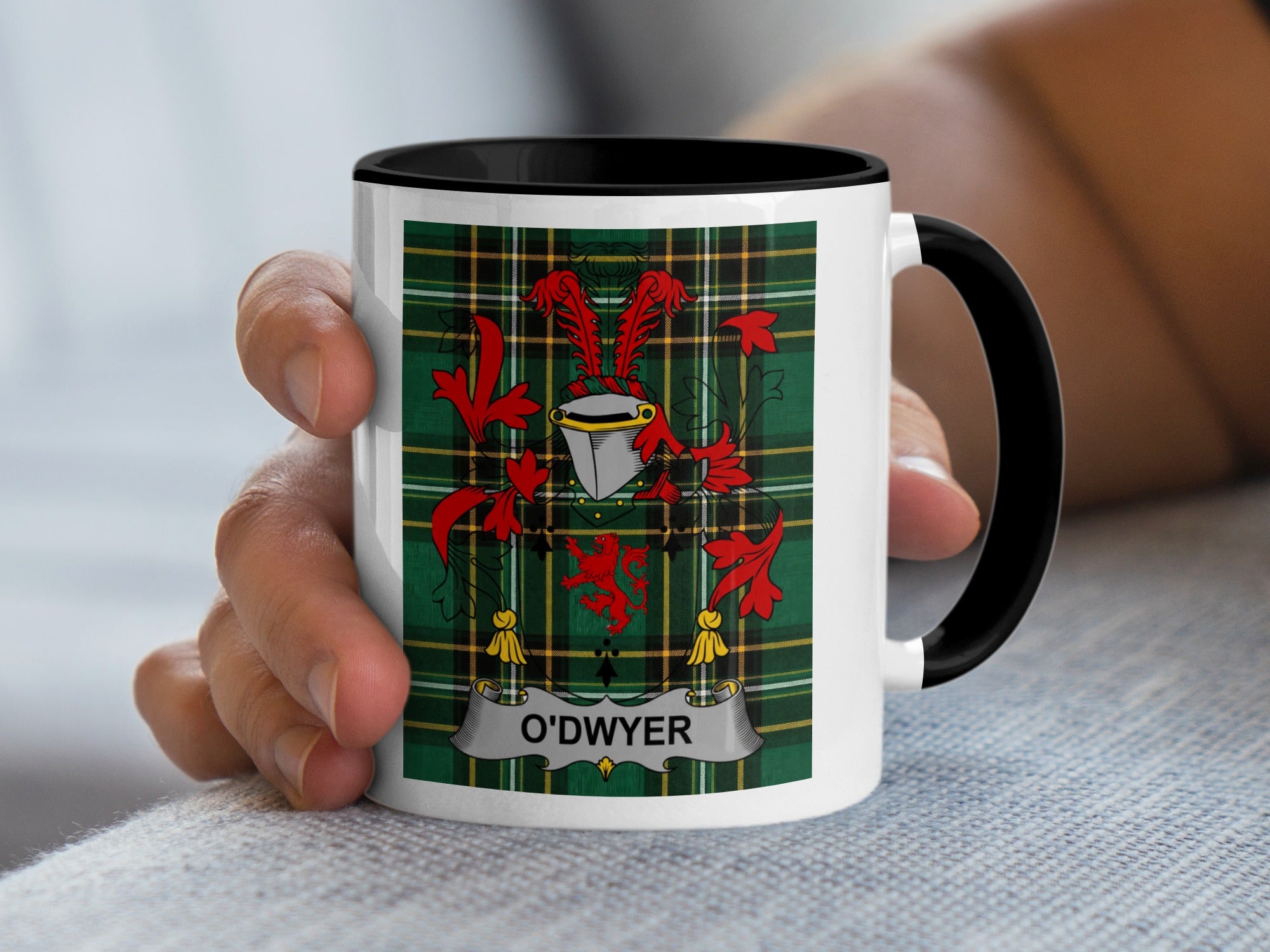 O'Dwyer family crest Irish heritage mug held in hand — tartan background