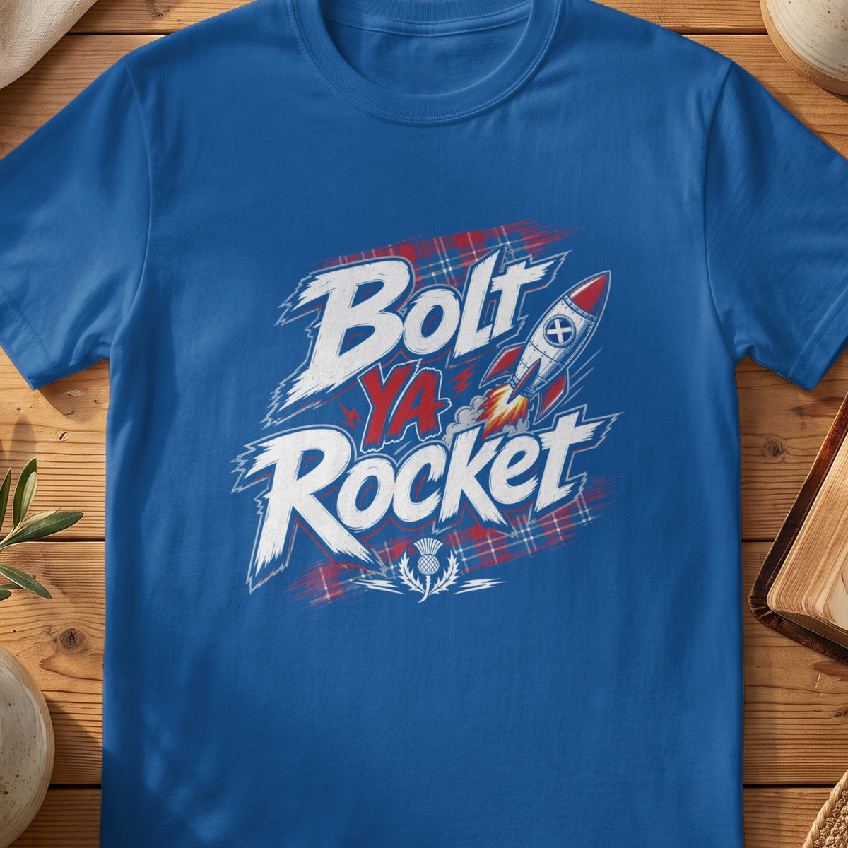 Blue t-shirt with "Bolt Ya Rocket" text, rocket, and Scottish thistle design.