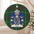 Cecil ornament hanging from a pale wooden branch; six small black shields bearing white lions over blue-and-white vertical stripes on Welsh national tartan.