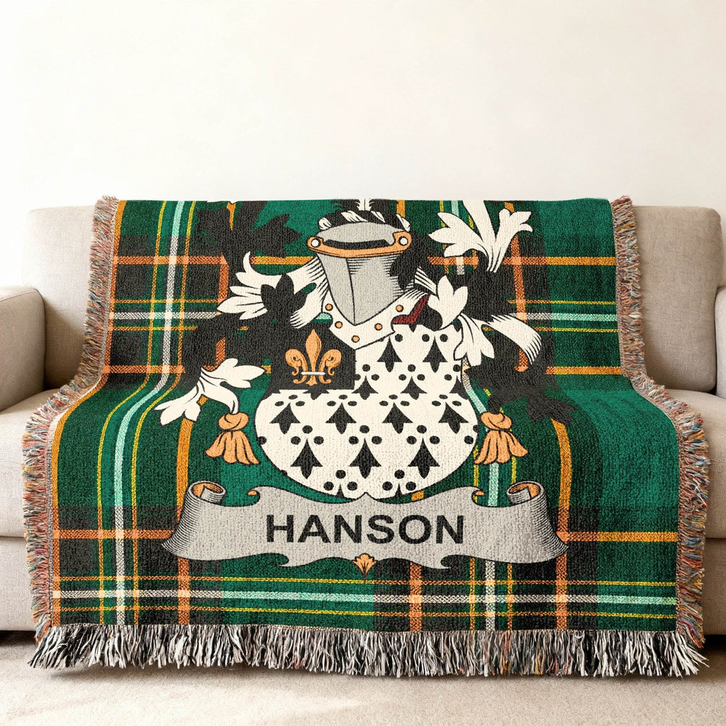 Tapestry throw blanket with green plaid and embroidered Hanson family crest.