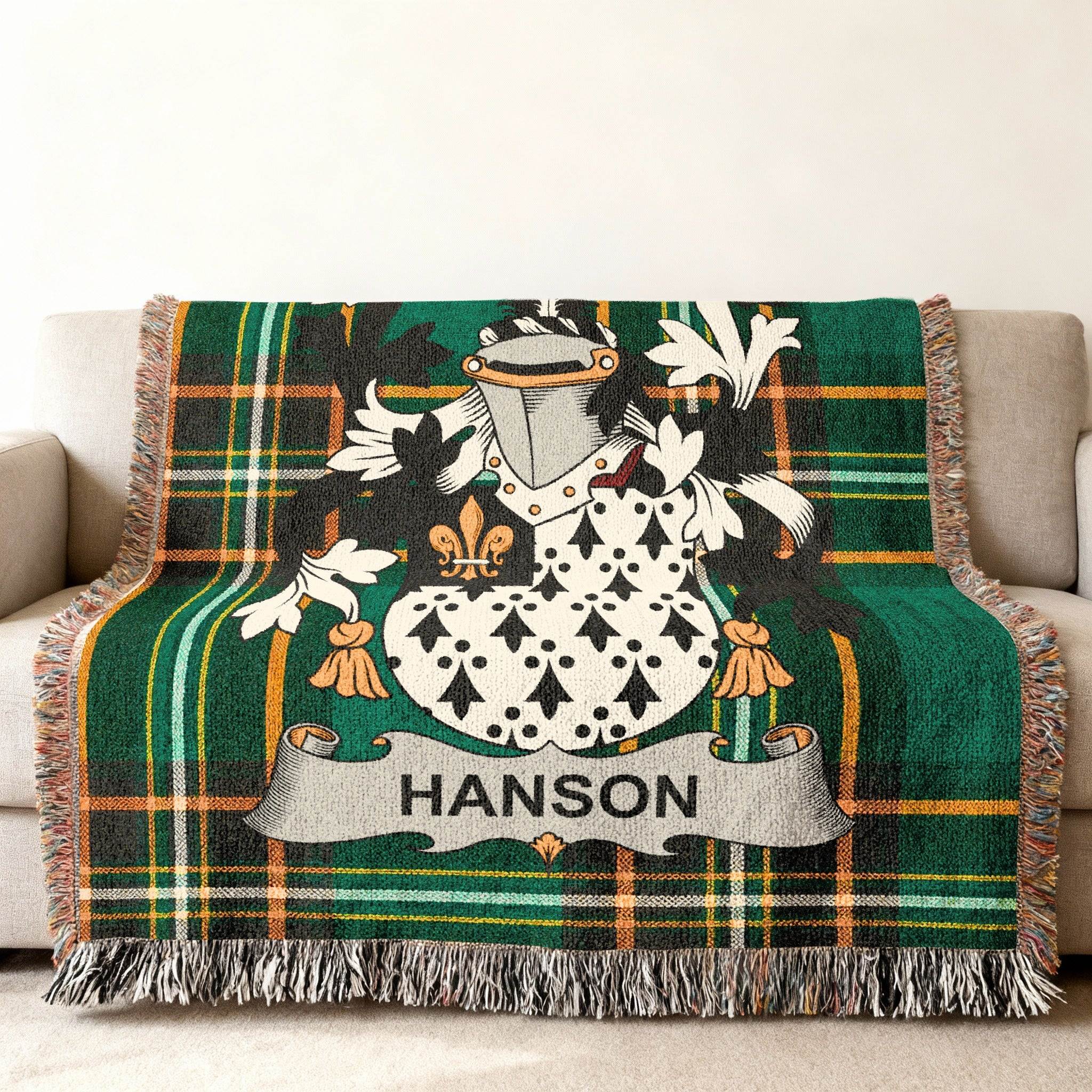 Tapestry throw blanket with green plaid and embroidered Hanson family crest.