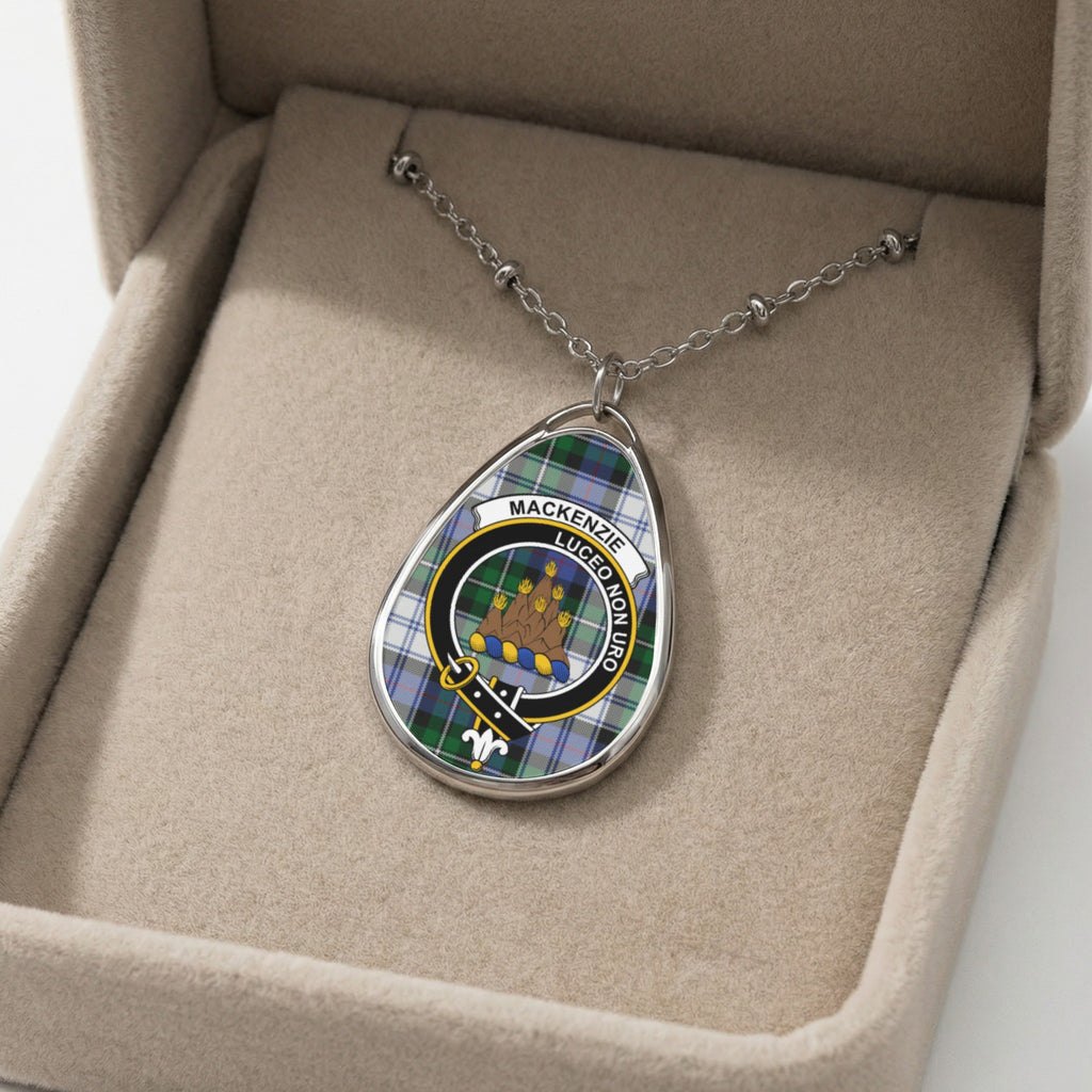 Oval pendant with Mackenzie tartan and crest on a silver chain in a box.